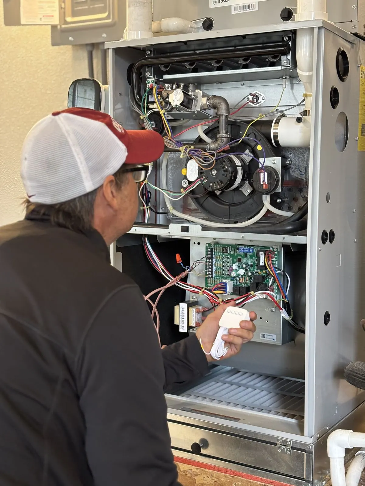 Delta T technician using a clamp meter on an HVAC system